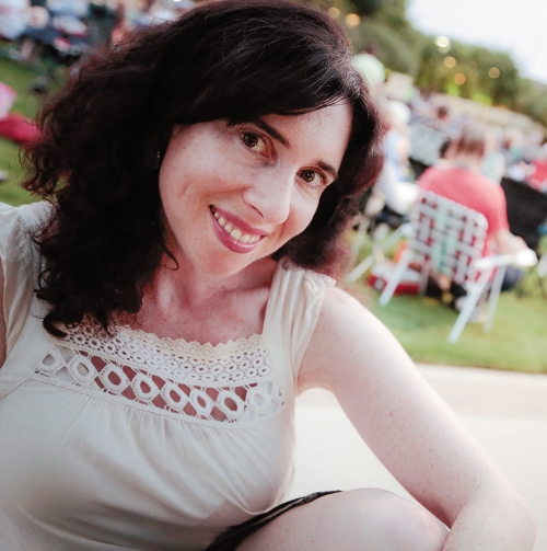 A woman with dark hair smiles at the camera. 